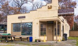 Historic Wilson Grocery in Idlewild, Michigan. It's a small tan building. There's a brown sign with the store's anem