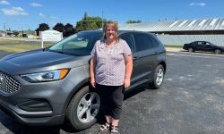 Tracy Antkoviak standing next to a car