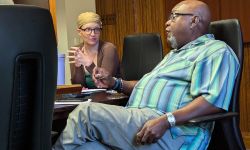 Cara Poland and Tommy Stallworth sitting on a table 