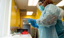 Beth Schuckman, an emergency medical technician, processes a COVID test at New Hope Wellness Center